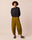 model wears dana golden olive cotton trousers left