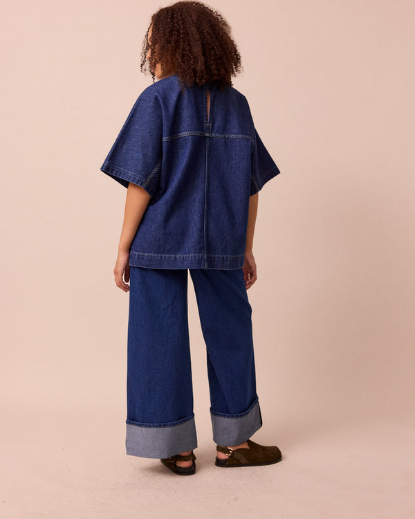 model wears teddi mid blue wash denim trousers left