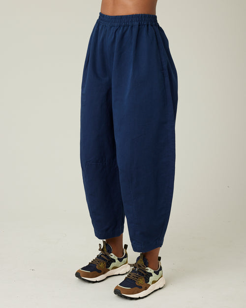 model wears navy daisy twill trousers left