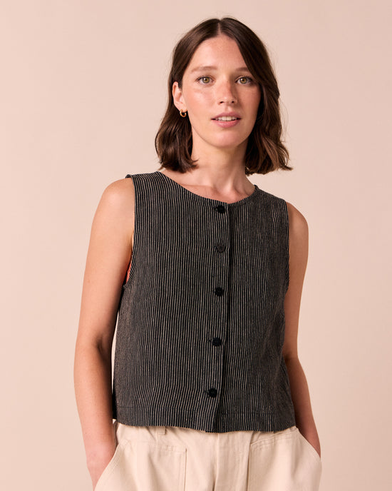 model wears elodie black and ecru pencil stripe linen top. 