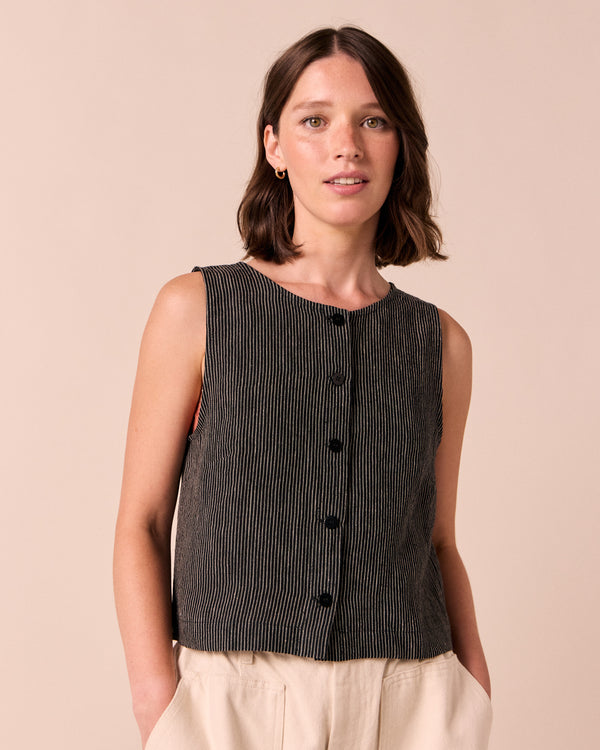 model wears elodie black and ecru pencil stripe linen top. 