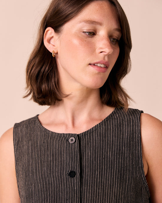 model wears elodie black and ecru pencil stripe linen top. 