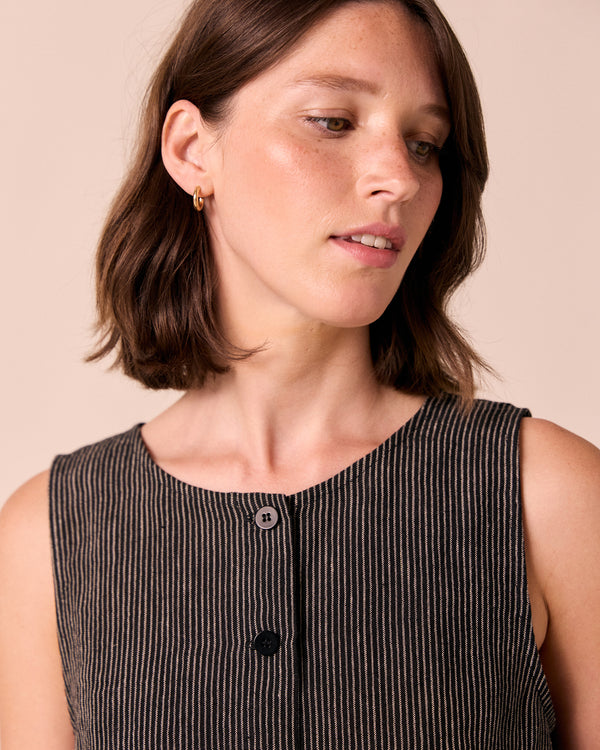 model wears elodie black and ecru pencil stripe linen top. 