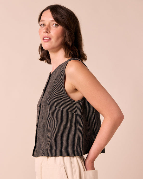 model wears elodie black and ecru pencil stripe linen top. 