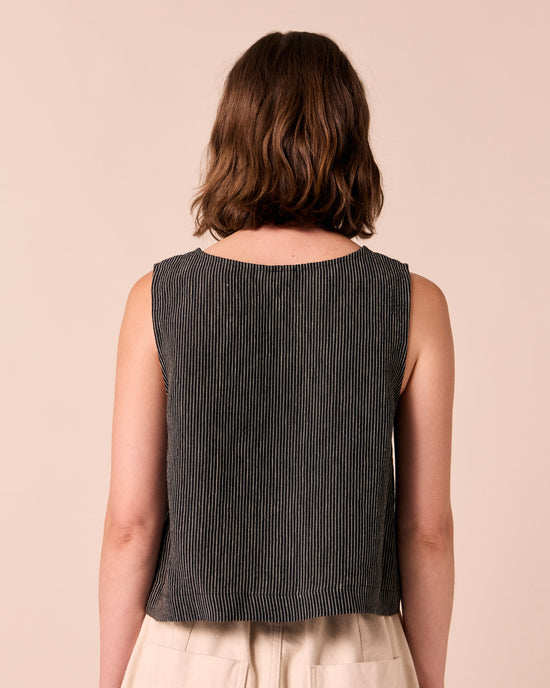 model wears elodie black and ecru pencil stripe linen top. 