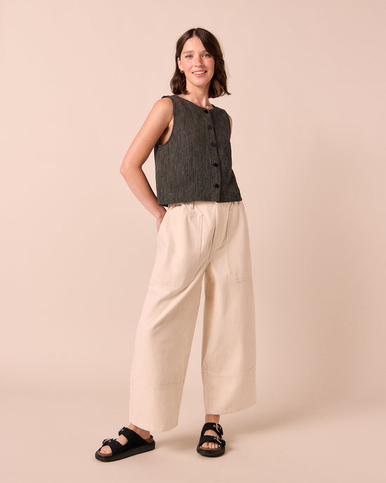 model wears elodie black and ecru pencil stripe linen top. 