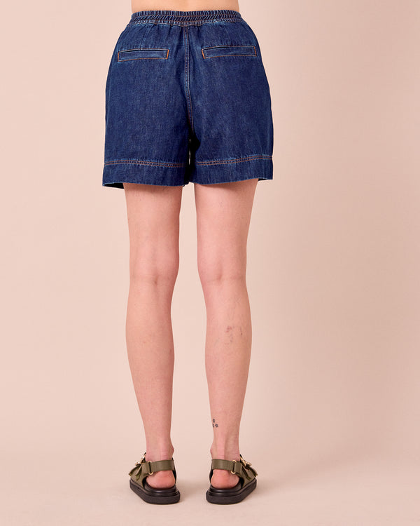 model wears ember mid blue denim shorts