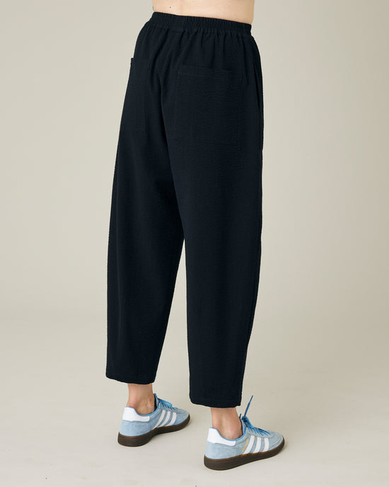 model wears black seersucker huxley trousers right