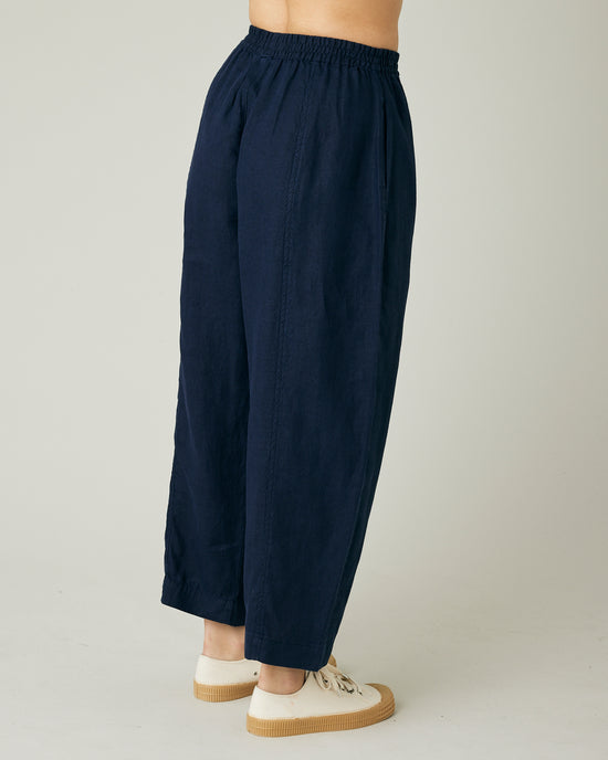 model wears navy linen mabel trousers to the right