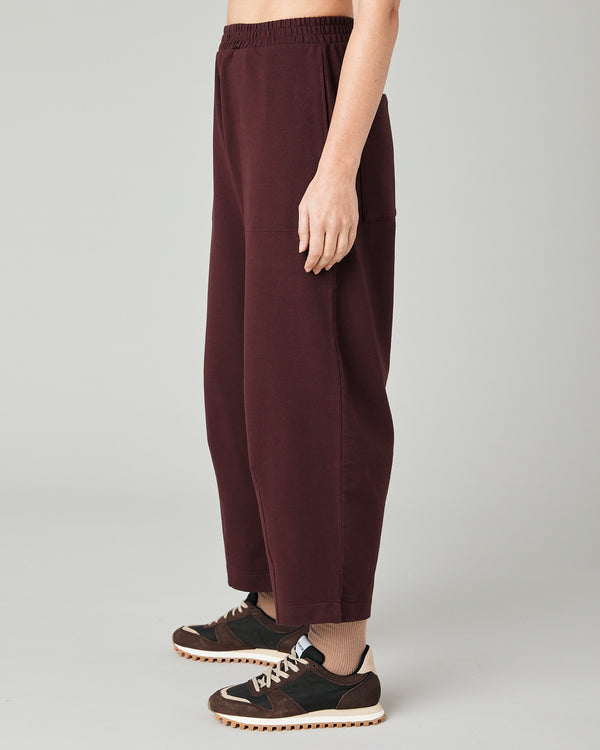 model wears burgundy huxley jersey trousers left