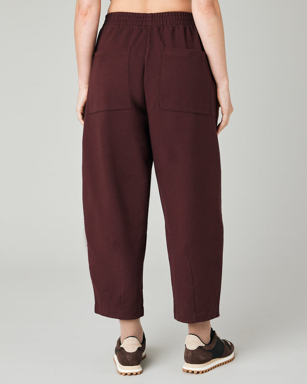 model wears burgundy huxley jersey trousers back
