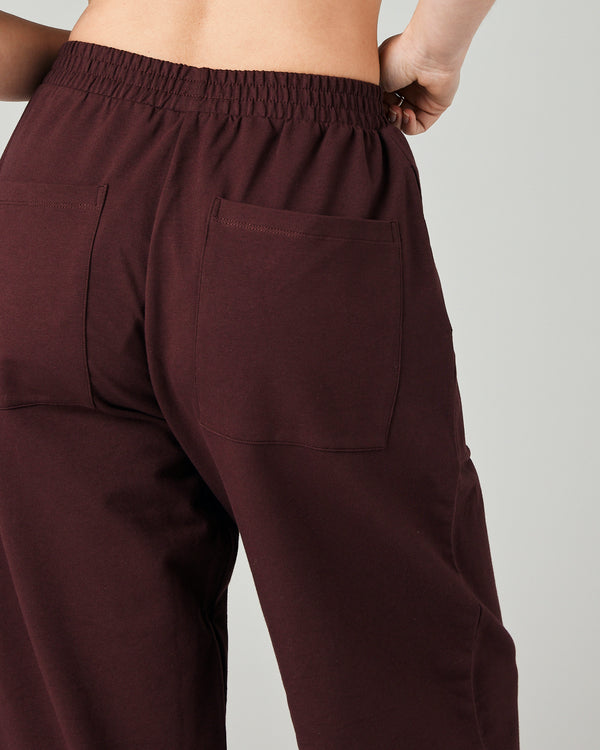 model wears burgundy huxley jersey trousers