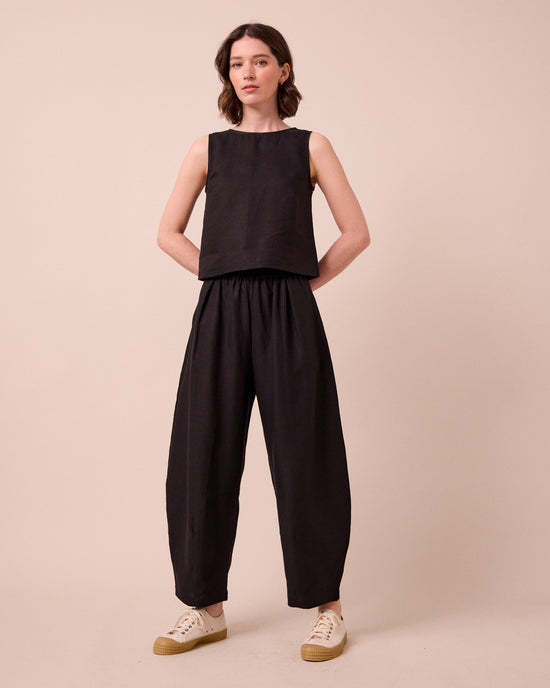 model wears daisy black linen trousers left