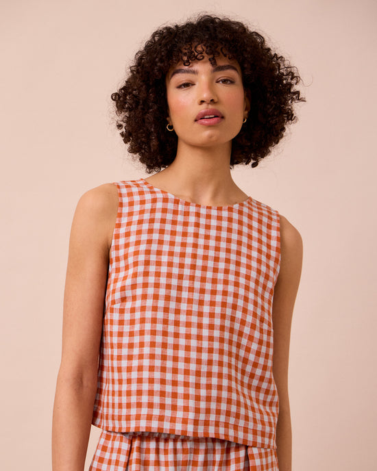 model wears esme burnt orange gingham linen top