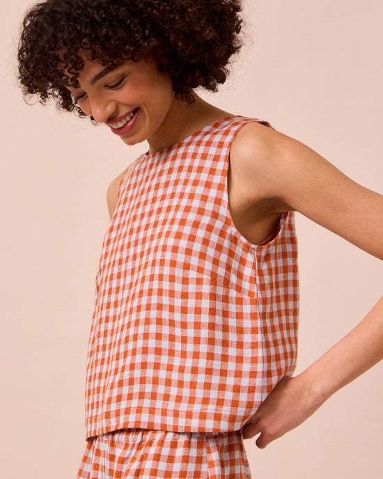 model wears esme burnt orange gingham linen top