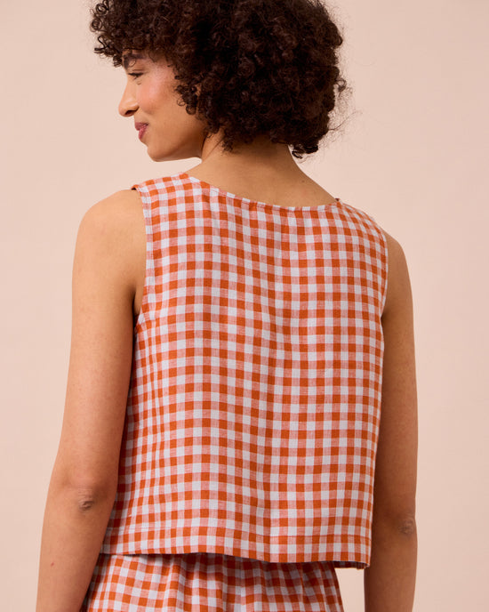 model wears esme burnt orange gingham linen top