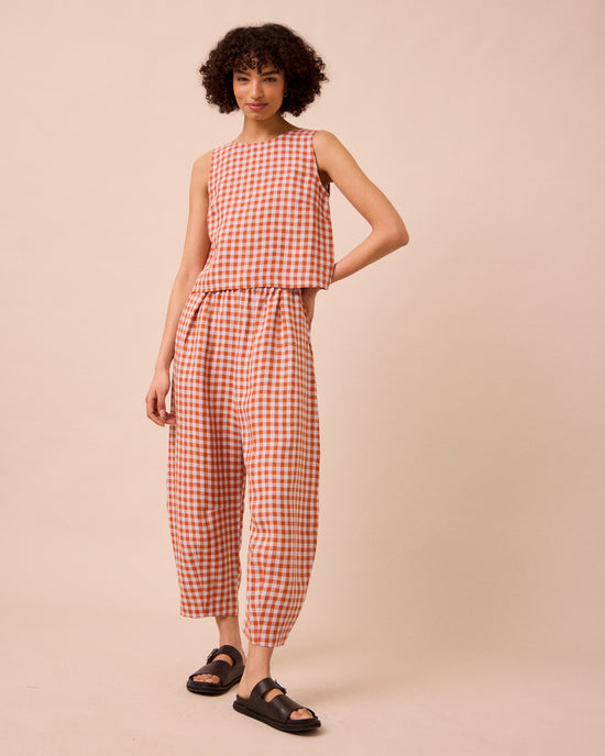 model wears esme burnt orange gingham linen top