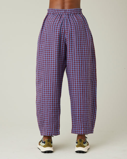 model wears blueberry check linen trousers to the back