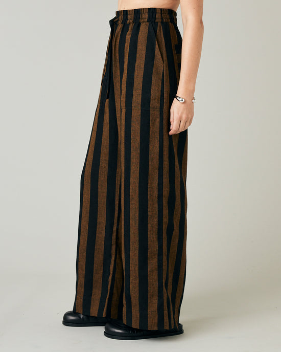 model wears rust stripe lexi linen trousers left