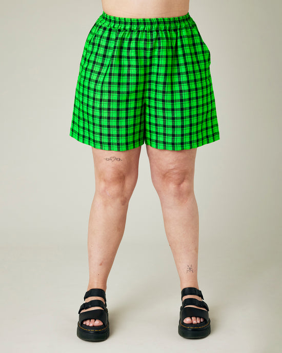 model wears green and black check ari shorts