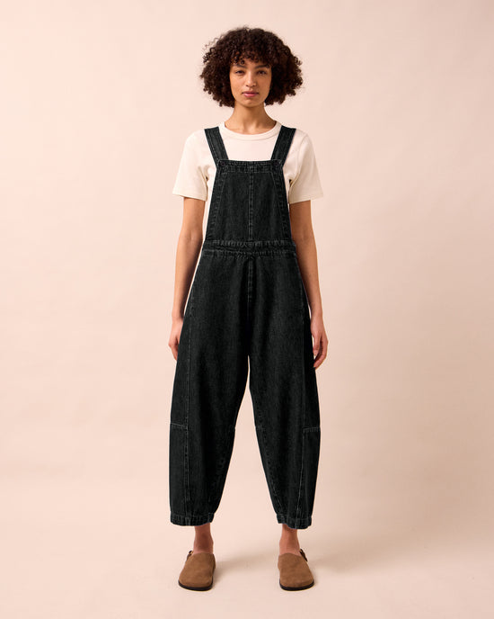 model wears gwynne washed black denim jumpsuit
