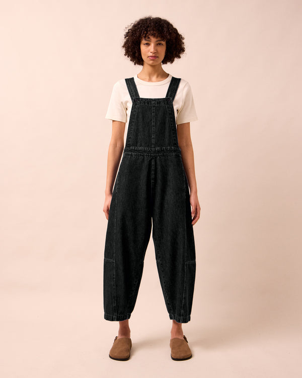 model wears gwynne washed black denim jumpsuit