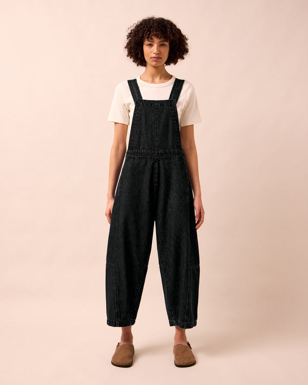 model wears gwynne washed black denim jumpsuit