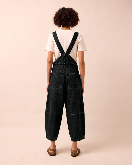 model wears gwynne washed black denim jumpsuit