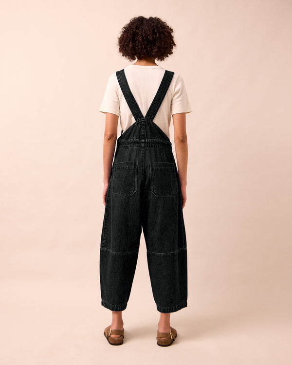 model wears gwynne washed black denim jumpsuit