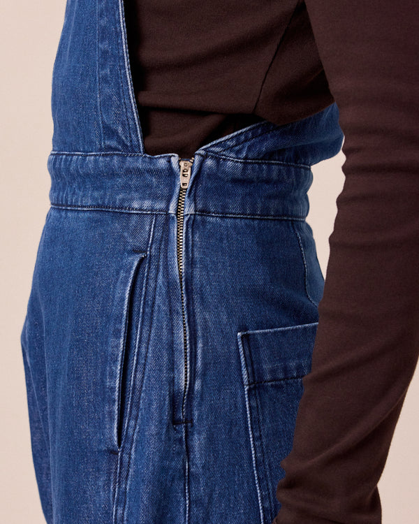 model wears gwynne mid blue denim dungerees