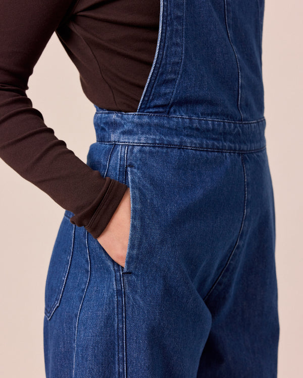 model wears gwynne mid blue denim dungerees