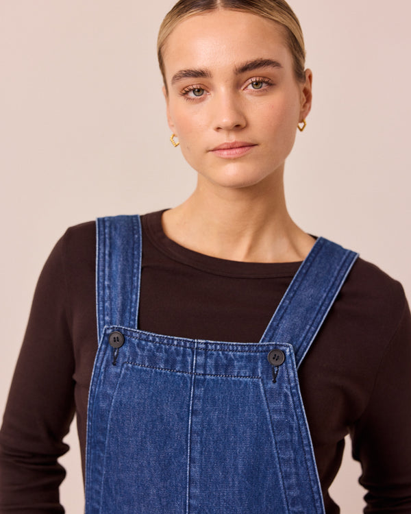 model wears gwynne mid blue denim dungerees