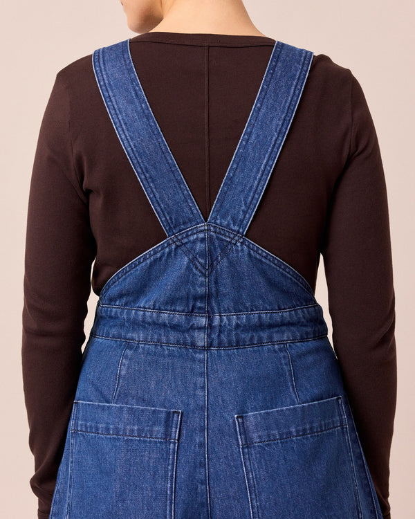 model wears gwynne mid blue denim dungerees