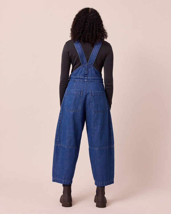 model wears gwynne mid blue denim dungerees