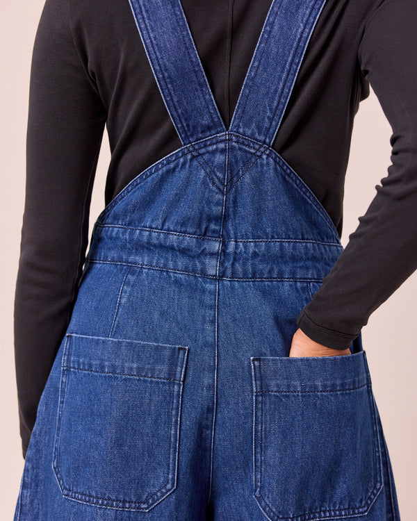 model wears gwynne mid blue denim dungerees