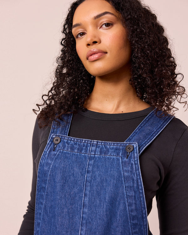 model wears gwynne mid blue denim dungerees
