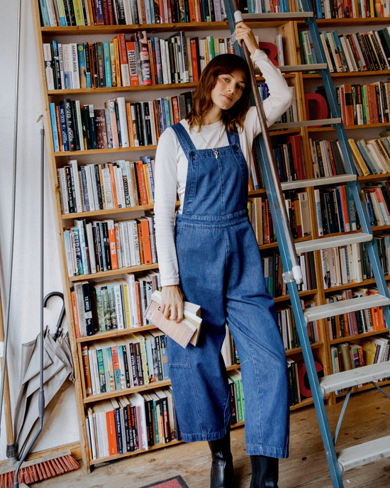 model wears gwynne mid blue denim dungerees