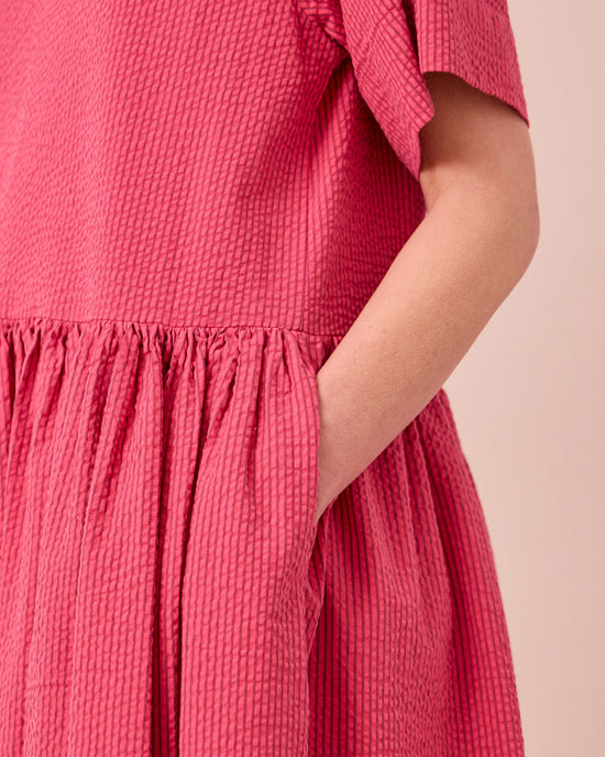 model wears harper raspberry stripe seersucker dress