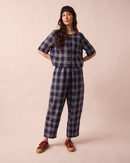 model wears huxley navy plaid linen trousers left