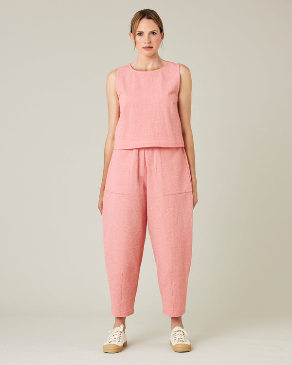 model wears coral seersucker huxley trousers