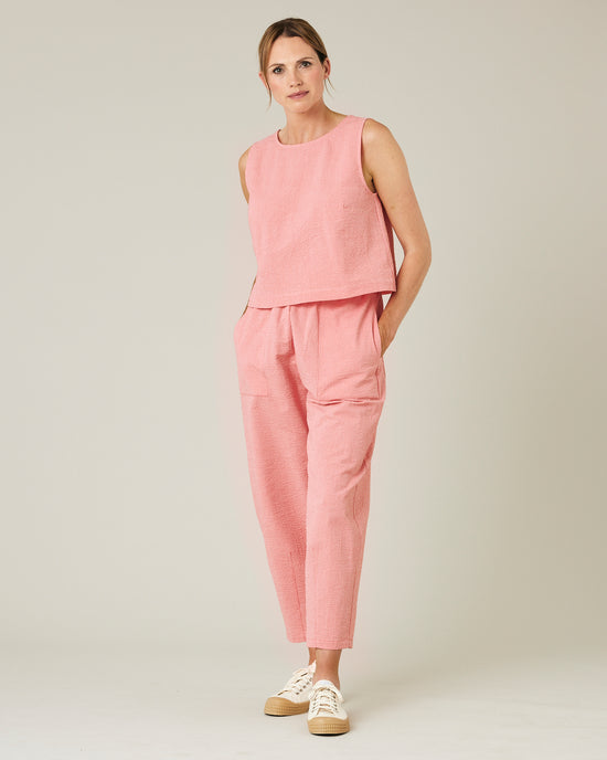 model wears coral seersucker huxley trousers