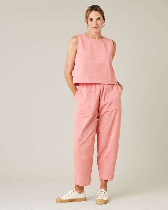 model wears coral seersucker huxley trousers