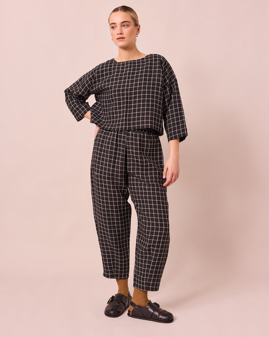 model wears huxley black grid linen trousers right