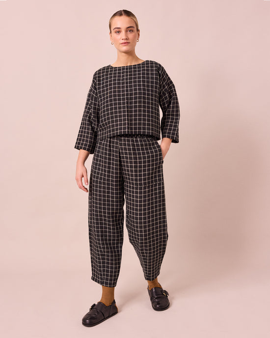 model wears huxley black grid linen trousers left