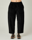 model wears black huxley cord trousers front