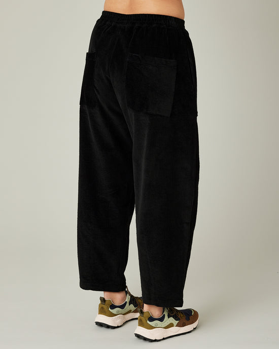 model wears black huxley cord trousers right