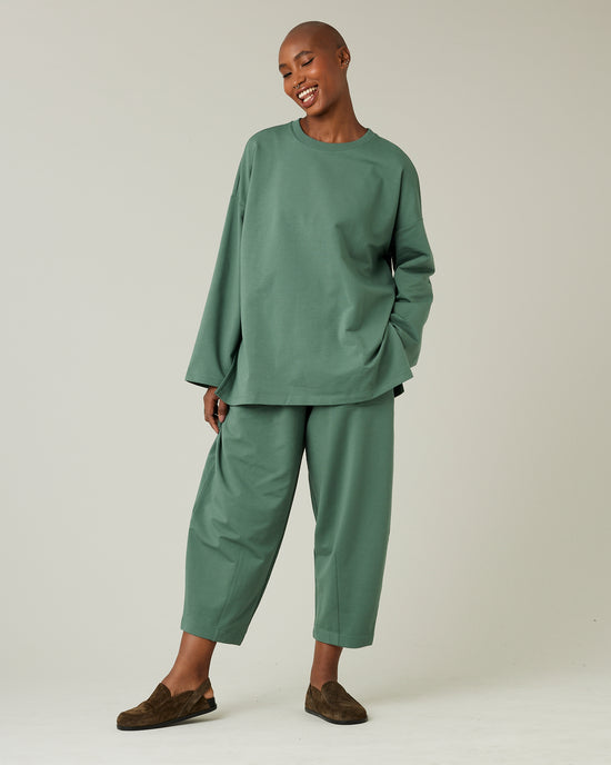 model wears dusty green huxley jersey trousers