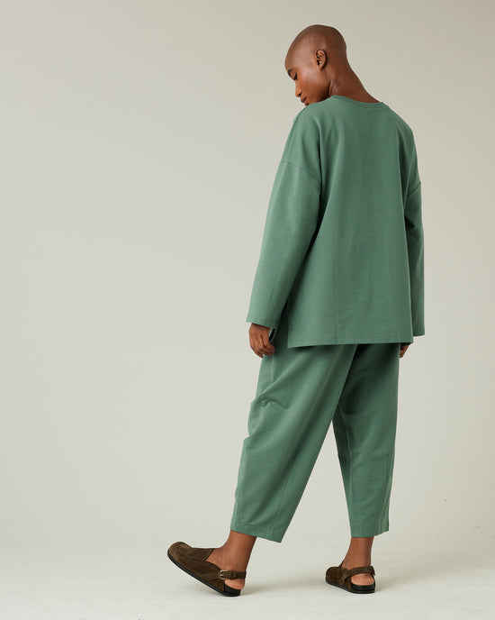 model wears dusty green huxley jersey trousers