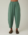 model wears dusty green huxley jersey trousers front