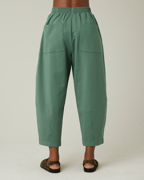 model wears dusty green huxley jersey trousers back